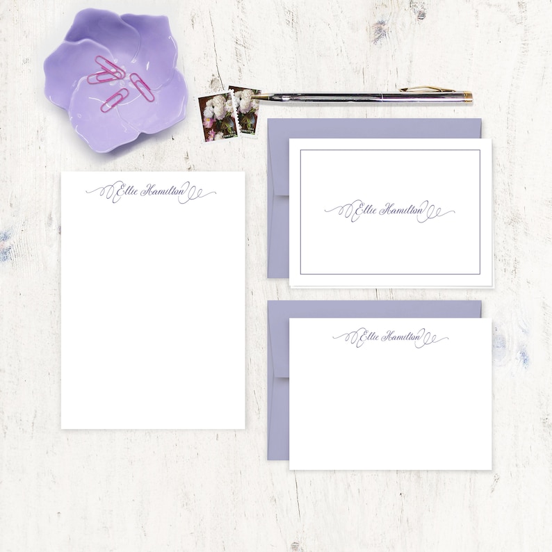 May include: A set of three white stationery cards with a lavender envelope. The cards feature a handwritten script font with the name "Ellie Hamilton" on each card.