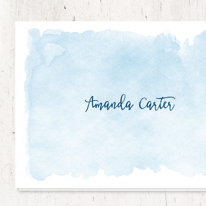 Puede incluir: Un fondo de acuarela azul claro con el nombre "Amanda Carter" escrito en cursiva azul oscuro.
