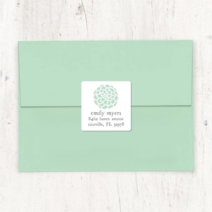May include: A white square return address label with a light green floral design. The text reads "emily myers, 8462 haven avenue, niceville, FL 32578".