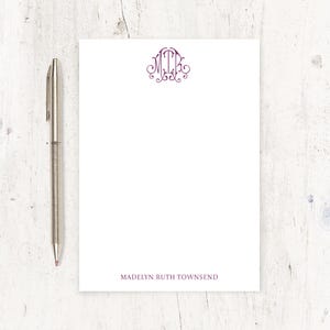 May include: A white notepad with a purple monogram of the letters "MRT" in a decorative font. The notepad has the name "Madelyn Ruth Townsend" printed at the bottom.