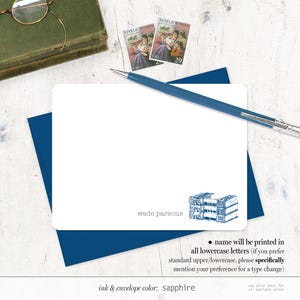 May include: A white card with blue trim and a stack of books illustration. The text on the card reads "wade parsons" and "ink & envelope color: sapphire". The card also includes instructions for printing the name in all lowercase letters.