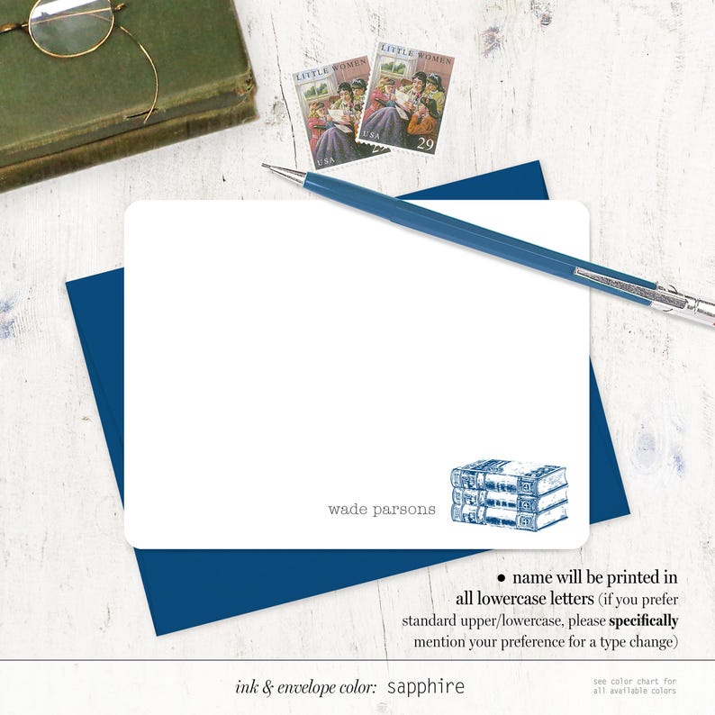 May include: A white card with blue trim and a stack of books illustration. The text on the card reads "wade parsons" and "ink & envelope color: sapphire". The card also includes instructions for printing the name in all lowercase letters.