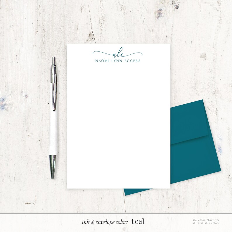May include: A white stationery set with a teal envelope. The stationery has a simple, elegant design with the name "NAOMI LYNN EGGERS" and the initials "NLE" in a cursive font. The ink and envelope color is teal.