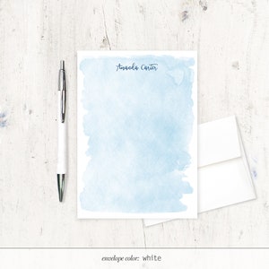 May include: A light blue watercolour stationery set with the name "Amanda Carter" printed at the top. The envelope is white.