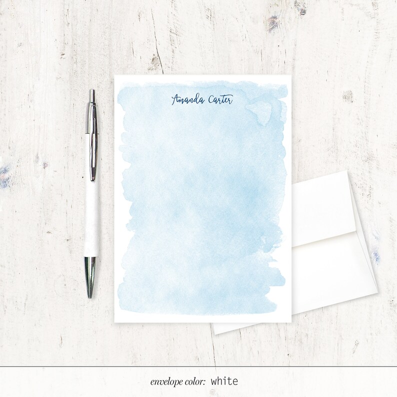 May include: A light blue watercolour stationery set with the name "Amanda Carter" printed at the top. The envelope is white.