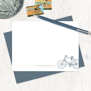 May include: A white card with a blue border and a bicycle illustration in the bottom right corner. The text "thomas johnson" is printed in the bottom left corner.