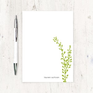 May include: White stationery card with a green leafy plant design and the name "lauren sullivan" printed at the bottom.