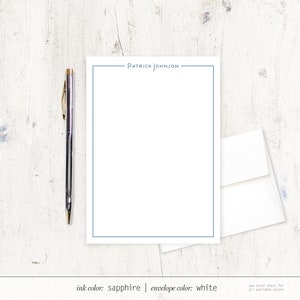 K&ouml;nnte beinhalten: Ein wei&szlig;es Briefpapier-Set mit einem blauen Rand und dem Namen "PATRICK JOHNSON" oben gedruckt. Die Tintenfarbe ist Saphir und die Farbe des Umschlags ist Wei&szlig;.