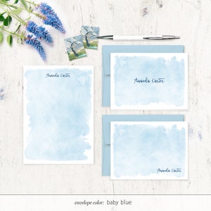 Puede incluir: Un juego de tres tarjetas de papeler&iacute;a de acuarela azul con el nombre "Amanda Carter" escrito en cursiva en cada tarjeta. Las tarjetas est&aacute;n sobre una superficie de madera blanca con un sobre azul y dos sellos.