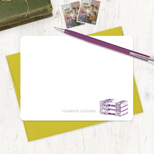 May include: A white card with a purple illustration of a stack of books. The card has the text "elizabeth sullivan" printed at the bottom.