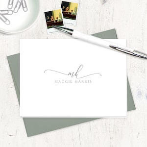 May include: A white card with a gray envelope. The card has a simple monogram design with the initials "mh" in cursive script and the name "Maggie Harris" printed below.