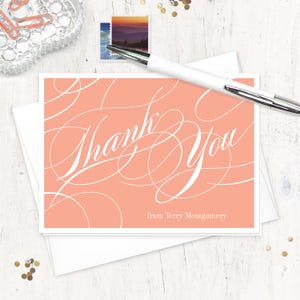 May include: A peach-colored thank you card with white cursive lettering that says "Thank You" and "from Terry Montgomery".