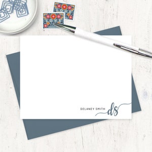 May include: A white card with a blue envelope. The card has a simple design with the text "DELANEY SMITH" and the initials "ds" in a cursive font.