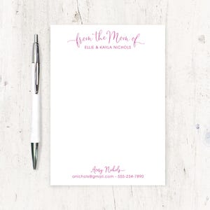 May include: White notepad with pink text that reads "from the Mom of Ellie & Kayla Nichols" at the top and "Avery Nichols anichols@gmail.com 555-234-7890" at the bottom.