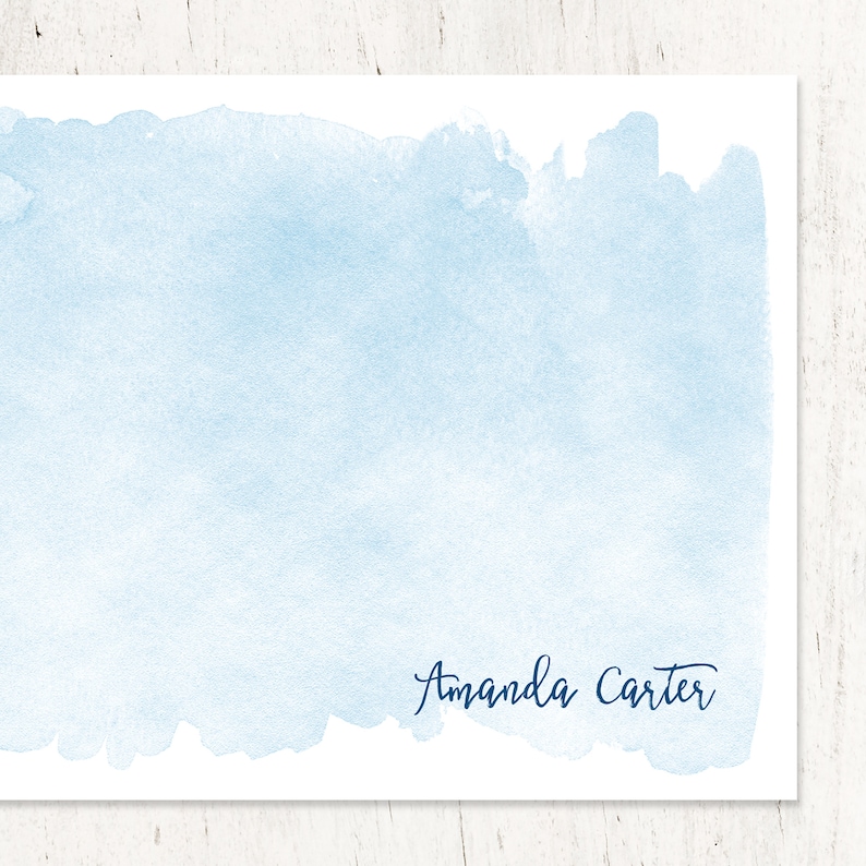 Puede incluir: Un fondo de acuarela azul claro con el nombre "Amanda Carter" escrito en cursiva azul oscuro.