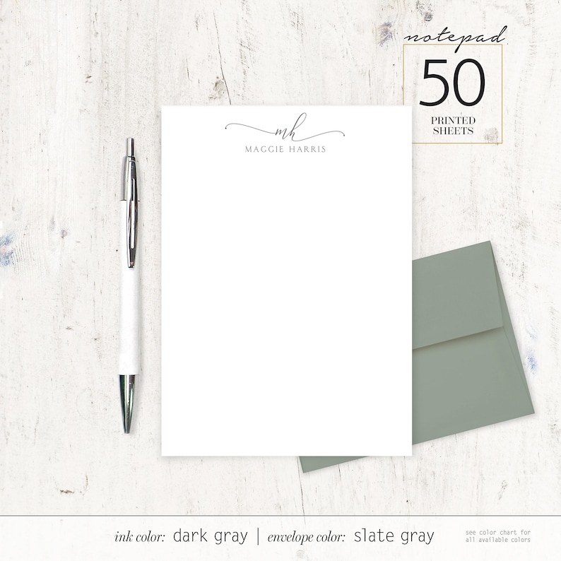 May include: A white notepad with 50 printed sheets. The notepad has a simple design with the initials "MH" and the name "Maggie Harris" printed at the top. The ink color is dark gray and the envelope color is slate gray.