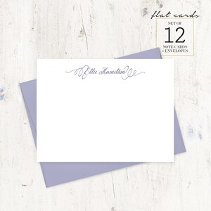May include: A set of 12 flat note cards with envelopes, featuring a cursive script that reads "Ellie Hamilton". The cards are white and the envelopes are a light purple.