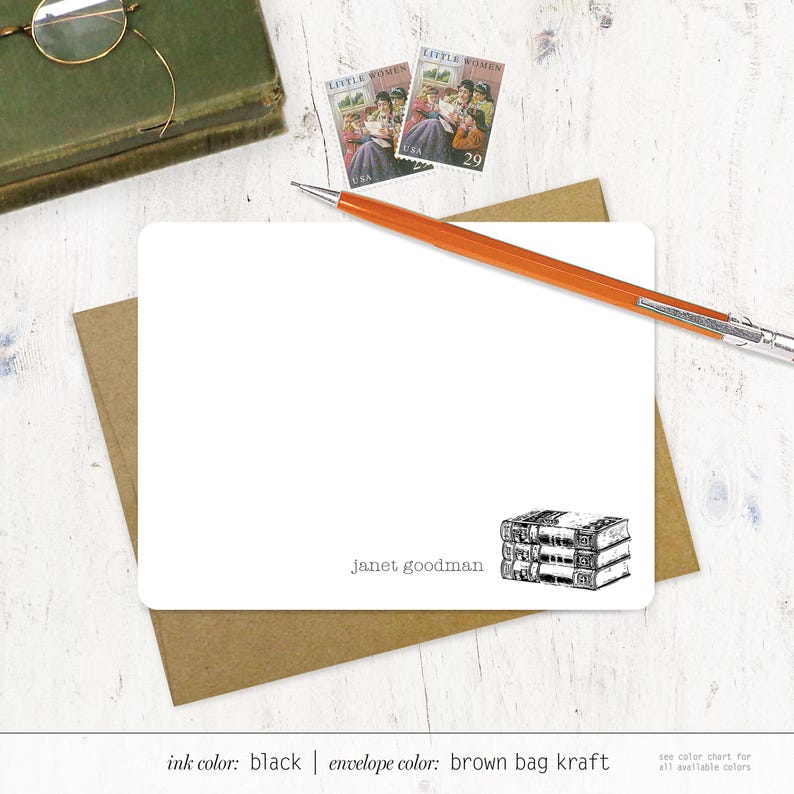 May include: A blank white card with a brown envelope. The card has a black and white illustration of a stack of books and the text "Janet goodman". The envelope is brown kraft paper.