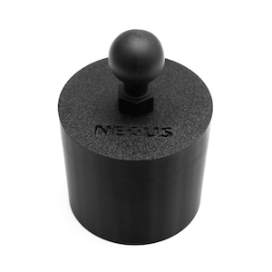 May include: A black cylindrical object with a ball-shaped top and the word "Nexus" embossed on the side. The object appears to be made of a textured, matte material. The top ball is connected to the cylinder with a hexagonal nut.