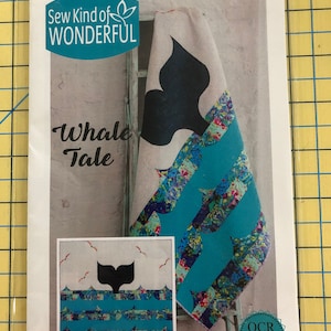 May include: A sewing pattern titled Whale Tale by Sew Kind of Wonderful, number 435. The cover features a quilt design with a black whale tail silhouette against a beige background, accented by teal and multi-colored floral patterned fabric strips.