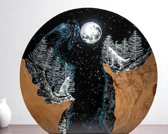 Puede incluir: Una obra de arte redonda de madera que representa una escena nocturna con dos lobos aullando a la luna. La obra tiene un fondo negro con árboles y estrellas blancas, y una luna llena. La base es de madera.