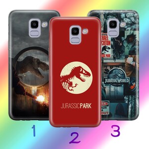 Op de afbeelding: Drie verschillende telefoonhoesjes met Jurassic Park-ontwerpen. De eerste hoes is zwart met een dinosaurus silhouet en een vergrootglas. De tweede hoes is rood met een wit dinosaurus silhouet en de tekst "Jurassic Park". De derde hoes is zwart en heeft een collage van Jurassic Park-afbeeldingen, waaronder een dinosaurus silhouet, de tekst "Jurassic World" en een waarschuwingsbord.