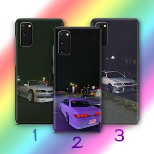 May include: Three phone cases with different designs. The first case is black with a white car on a dark road. The second case is black with a purple car on a dark road. The third case is black with a white car on a dark road.