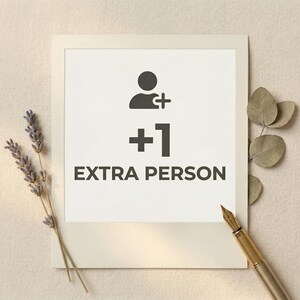 Könnte beinhalten: Eine weiße Karte im Polaroid-Stil mit einer schwarzen Grafik einer Person mit einem Pluszeichen, der Zahl +1 und den Worten "EXTRA PERSON". Die Karte ist von getrocknetem Lavendel, Eukalyptusblättern und einem goldenen Füllfederhalter umgeben.