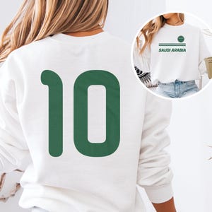 A white sweatshirt with the number 10 printed on it, along with the text "SAUDI ARABIA" printed on the front.