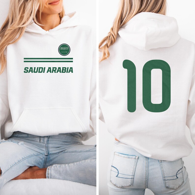 A woman wearing a white hoodie with the text "SAUDI ARABIA" printed on it, along with the number "10" on the back.