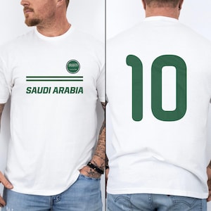 A white t-shirt with the text "SAUDI ARABIA" printed on it, along with a green number "10" on the back.