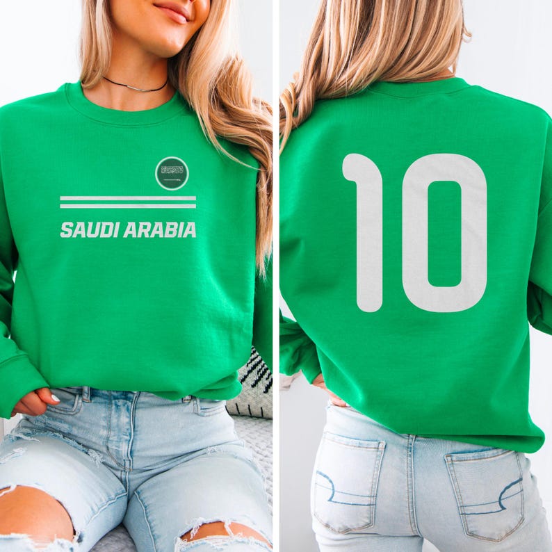 A woman wearing a green sweatshirt with the number 10 on it, and a logo that says "SAUDI ARABIA" printed on it.
