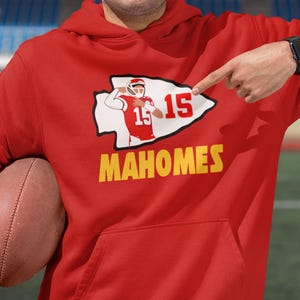 a man in a red hoodie pointing at a football
