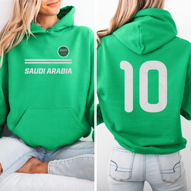 A woman wearing a green hoodie with the text "SAUDI ARABIA" and the number "10" on the back.