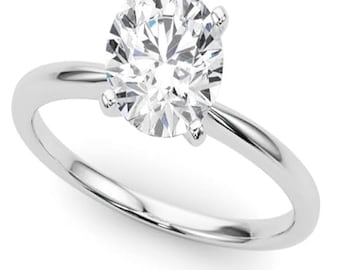 May include: A silver solitaire engagement ring with a round brilliant cut diamond.