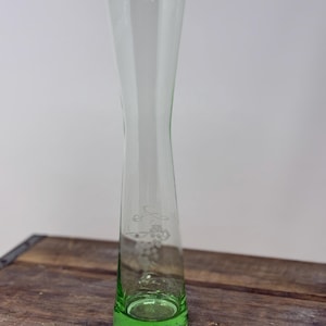 May include: A white ceramic mug with a black handle and the text "But First, Coffee" in a black, handwritten-style font. The mug is on a white surface.