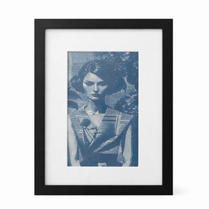Puede incluir: Una impresión artística enmarcada con un retrato en tonos azules de una mujer. La mujer lleva un vestido hecho de recortes de periódico. El fondo incluye elementos florales, todo dentro de un marco negro.