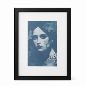 Puede incluir: Retrato enmarcado en tonos azules de una mujer con flores en el pelo y un vestido con estampado floral. La obra de arte está en un marco negro con un passe-partout blanco. La mujer tiene una expresión seria y lleva un pendiente grande.