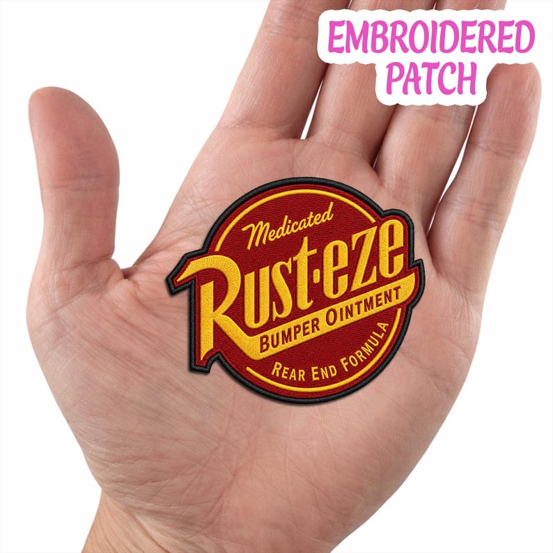 May include: A circular embroidered patch featuring a red background with a black border. The text reads Medicated Rust-eze Bumper Ointment Rear End Formula in yellow and white lettering. The patch is designed with a classic automotive logo style.