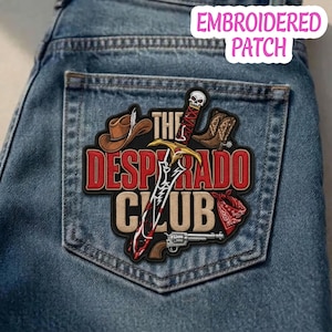 May include: An embroidered patch on blue denim fabric featuring a brown cowboy hat, a pair of brown cowboy boots, a red bandana, a silver revolver, and a sword with a skull pommel. The text reads THE DESPERADO CLUB in red and beige letters.