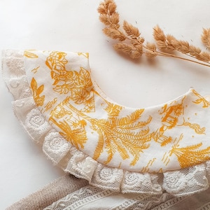 May include: A white collar with a yellow floral pattern and lace trim. The collar is made of a soft, lightweight fabric and is perfect for adding a touch of elegance to any outfit.