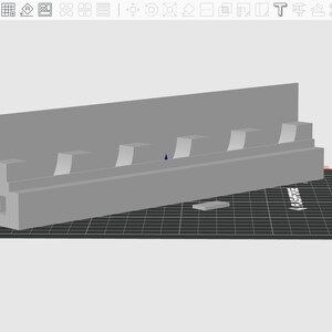 May include: A light gray 3D-printed object, possibly a shelf or holder, with multiple rectangular slots. The object is on a black surface with a grid pattern. The design is simple and geometric.
