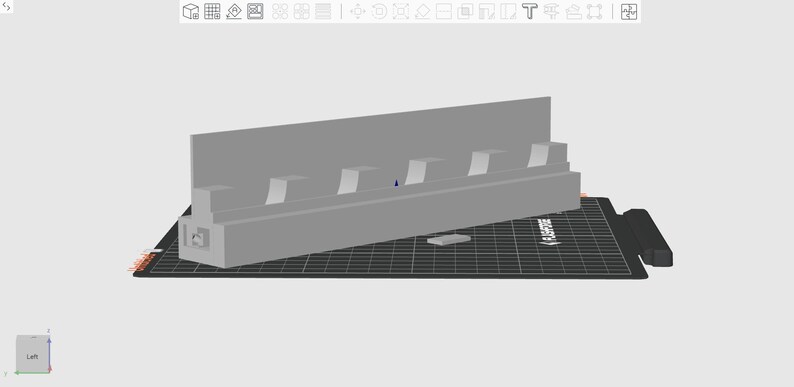 May include: A light gray 3D-printed object, possibly a shelf or holder, with multiple rectangular slots. The object is on a black surface with a grid pattern. The design is simple and geometric.