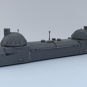 Puede incluir: Un modelo gris detallado de un tren futurista con dos grandes estructuras en forma de cúpula en la parte superior. El tren tiene un cuerpo largo y rectangular con múltiples ventanas y una serie de pequeños detalles rectangulares a lo largo de los lados.