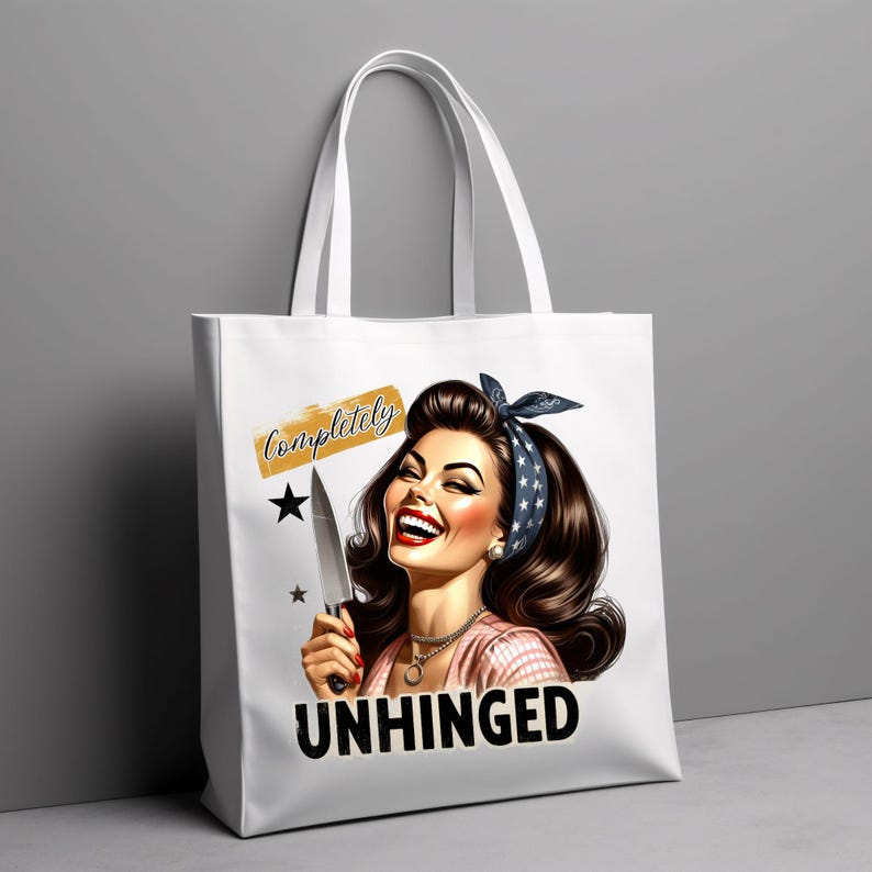 Puede incluir: Bolso tote blanco con una ilustraci&oacute;n retro de una mujer sonriente sosteniendo un cuchillo. El texto "Completely Unhinged" se muestra en el bolso. La mujer tiene cabello oscuro y lleva una diadema.