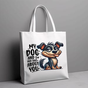 May include: White tote bag featuring a cartoon dog and the text "My Dog and I Talk Shit About You".