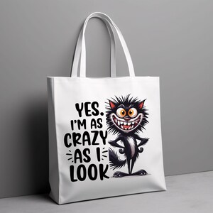 May include: White tote bag featuring a black and white cartoon cat with the text "YES. I'M AS CRAZY AS I LOOK" printed on it.