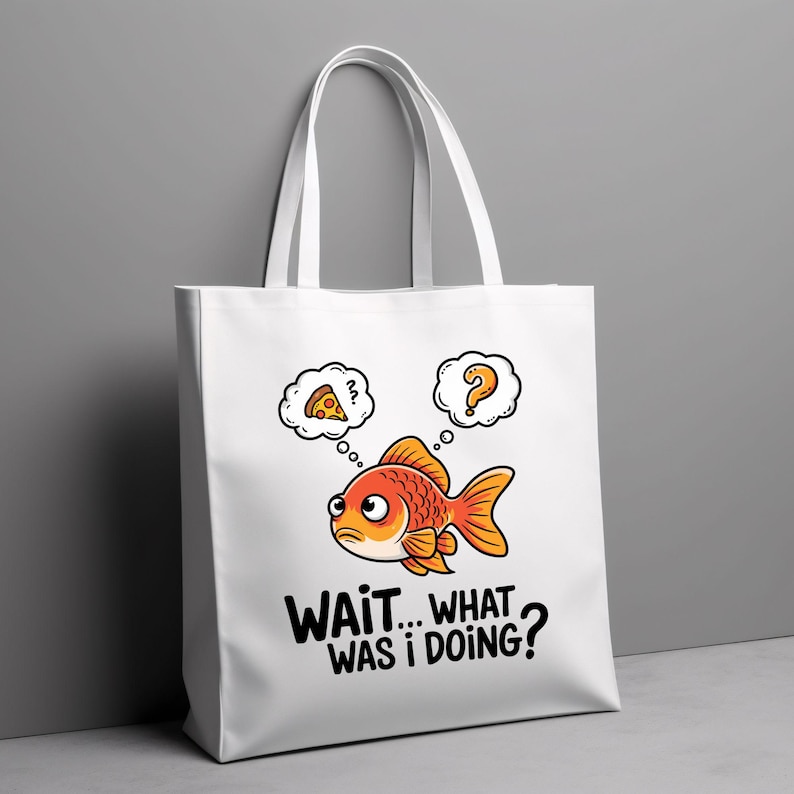 May include: White tote bag featuring a cartoon goldfish with thought bubbles above its head. One thought bubble contains a pizza slice, while the other has a question mark. The text on the bag reads "WAIT... WHAT WAS I DOING?"