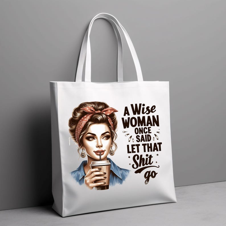 Puede incluir: Bolso tote blanco con un gr&aacute;fico de una mujer con un pa&ntilde;uelo rojo en la cabeza, sosteniendo una taza de caf&eacute;. El bolso tiene el texto "A Wise Woman Once Said Let That Shit Go" en negro. El bolso tiene asas blancas y un fondo gris.