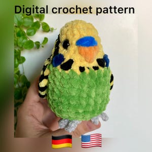 May include: A crocheted stuffed parakeet toy made with yellow, green and black yarn. The parakeet has a blue and orange beak.